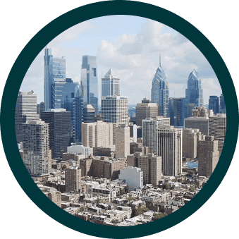 A city skyline with modern skyscrapers and various buildings under a cloudy sky, viewed through a circular frame.