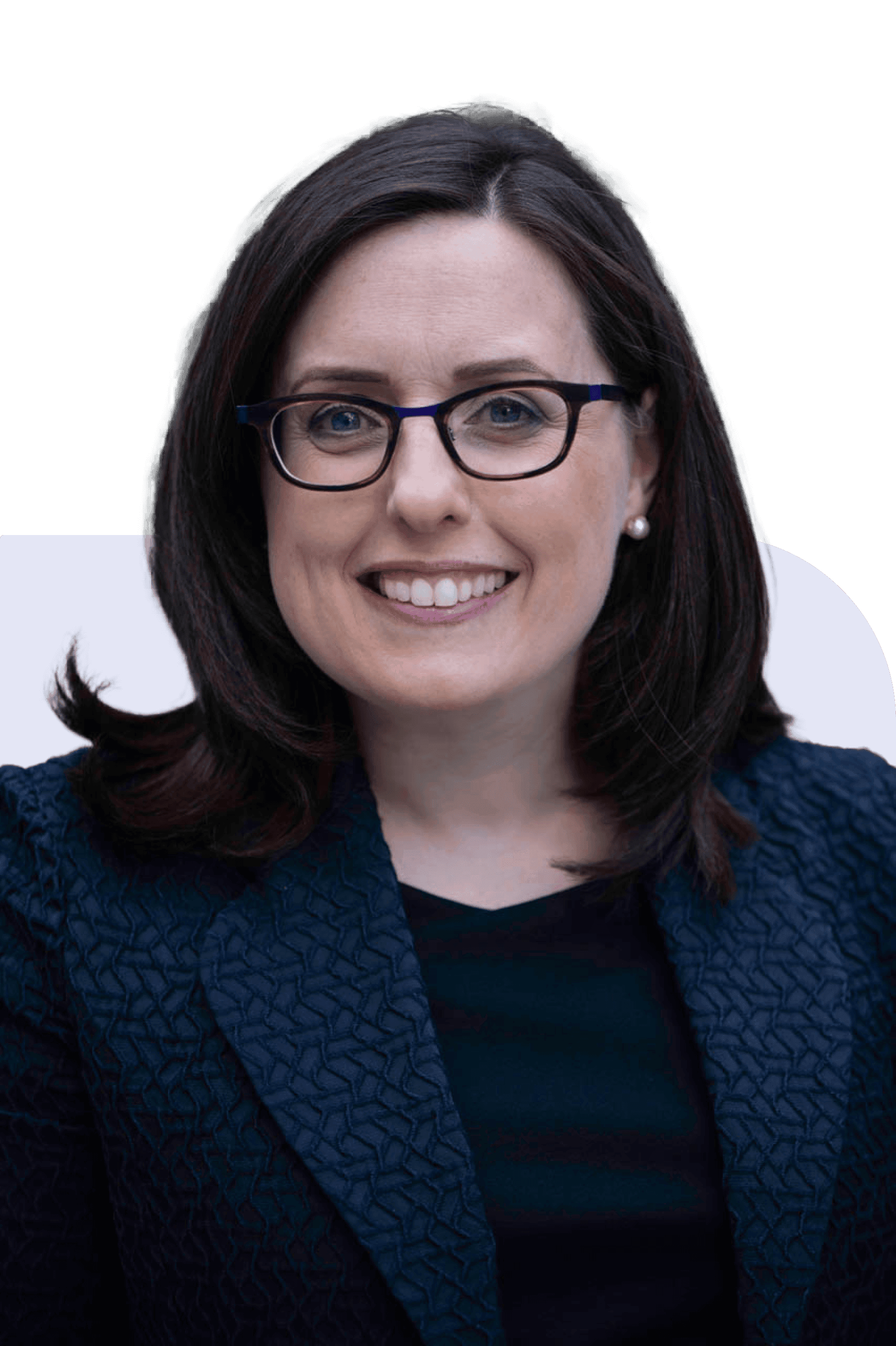 Woman in glasses and a dark textured blazer smiling against a dark background.