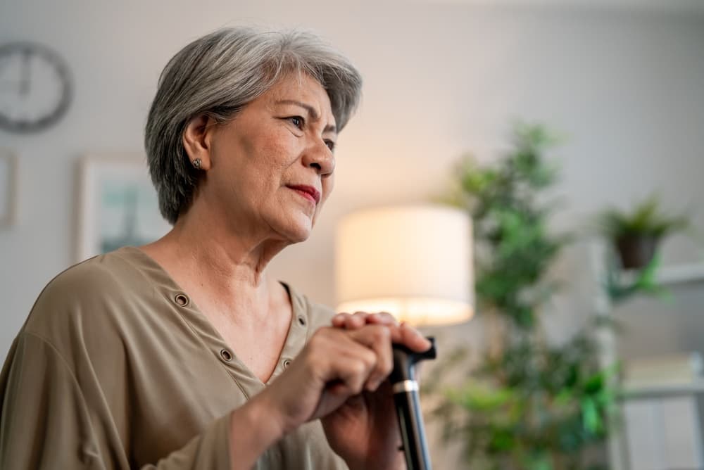 Older nursing home resident showing signs of emotional distress while speaking with a caregiver